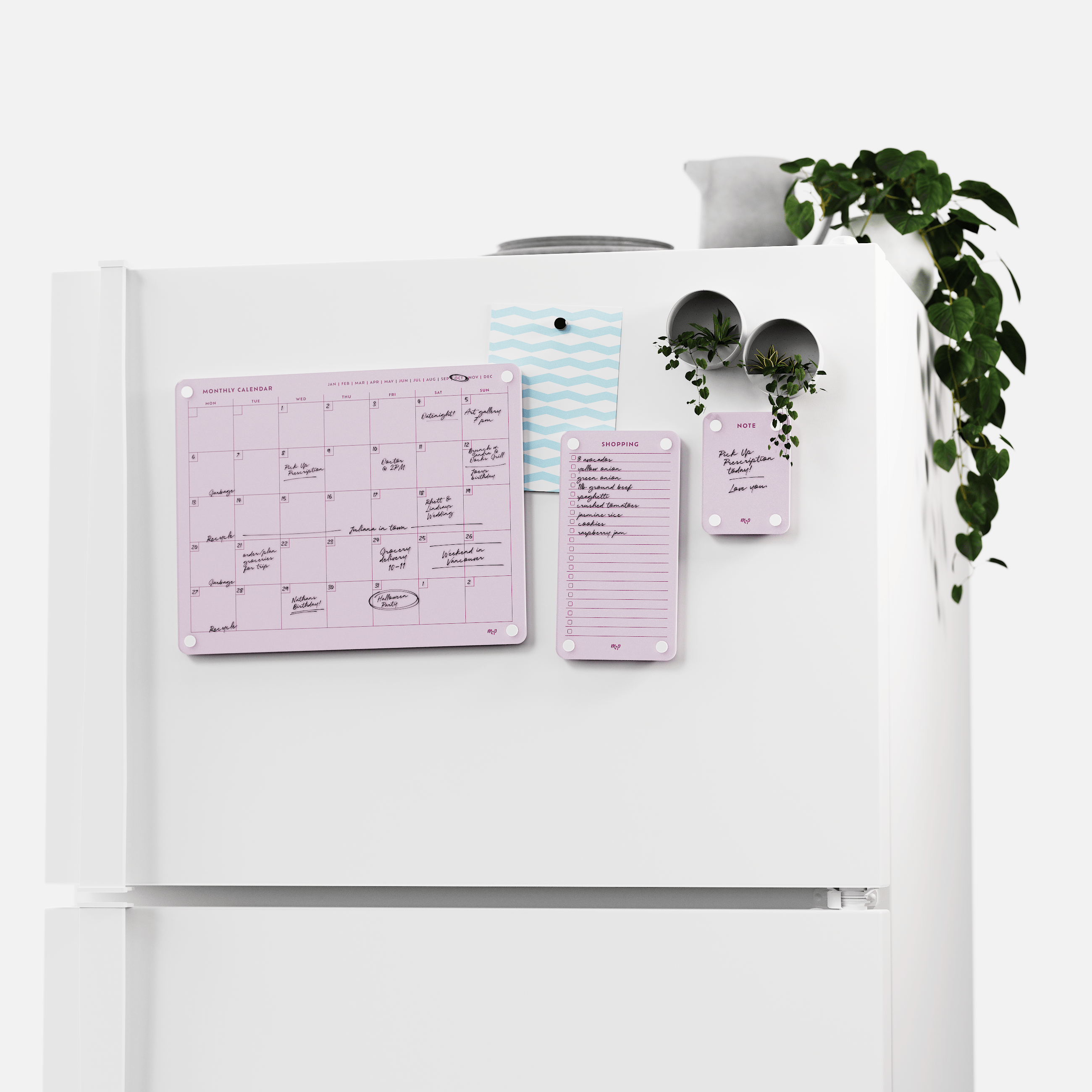 White fridge with the Ballet pink monthly calendar, shopping list and note board set, plants on top